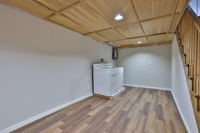 clothes washing area featuring baseboards, separate washer and dryer, wood finished floors, and laundry area