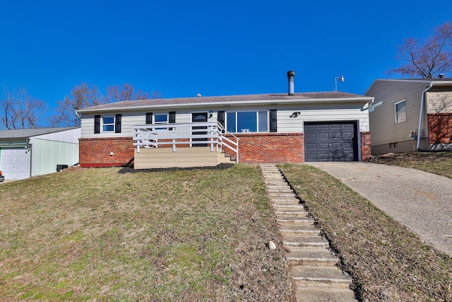 ranch-style home featuring stairway, concrete driveway, a front yard, a garage, and brick siding