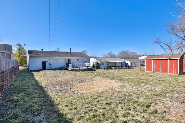 view of yard with an outbuilding, a wooden deck, and fence