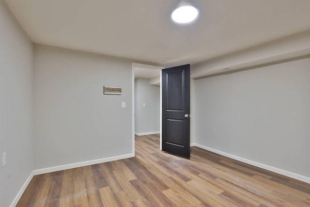 spare room featuring baseboards and wood finished floors