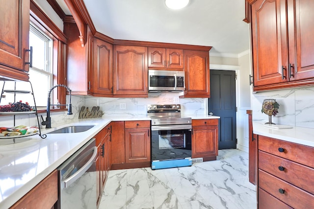 kitchen with crown molding, light countertops, appliances with stainless steel finishes, marble finish floor, and a sink