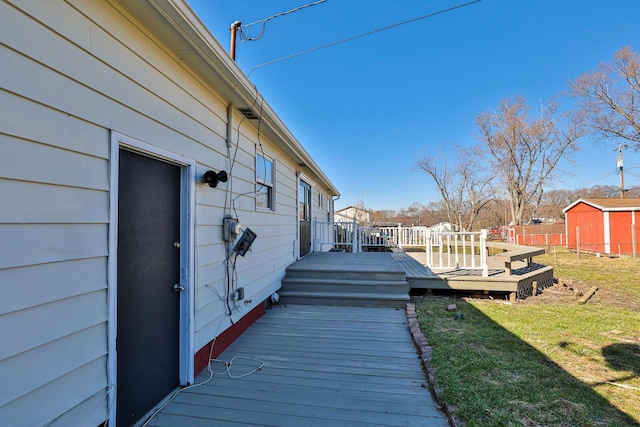 wooden terrace featuring a yard and fence