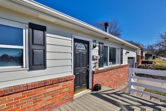 entrance to property featuring brick siding