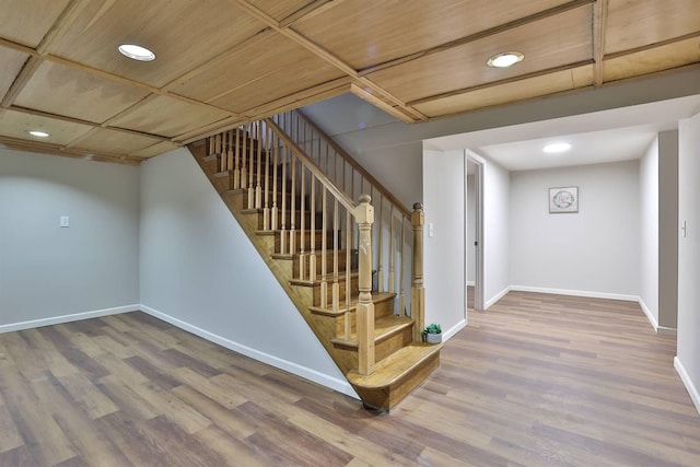 basement featuring stairs, wood finished floors, and baseboards