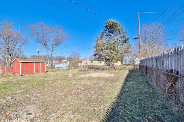 view of yard featuring a storage unit, an outdoor structure, and a fenced backyard