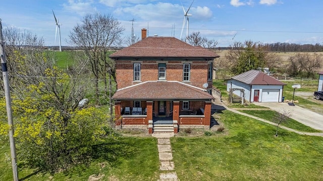 view of front of house featuring driveway, covered porch, an outdoor structure, a front yard, and brick siding