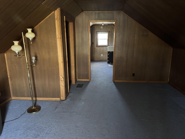 additional living space with carpet flooring, vaulted ceiling, and visible vents