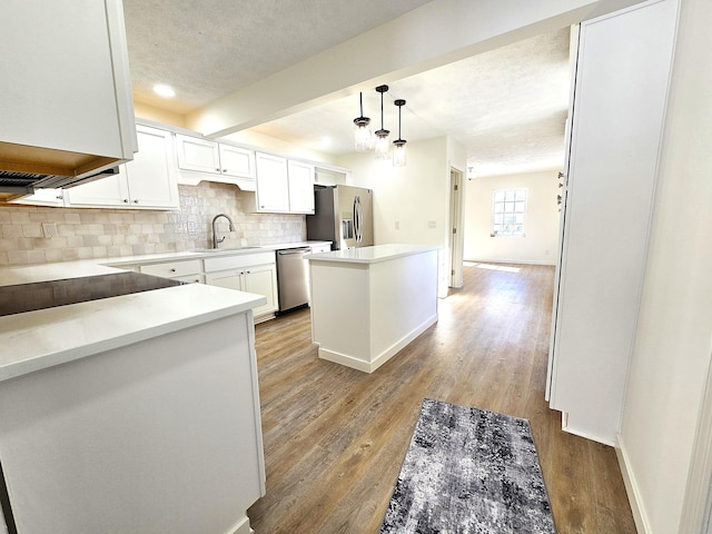 kitchen with tasteful backsplash, a center island, pendant lighting, stainless steel appliances, and white cabinets