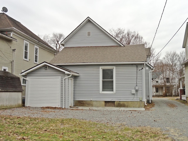 back of house with a shed