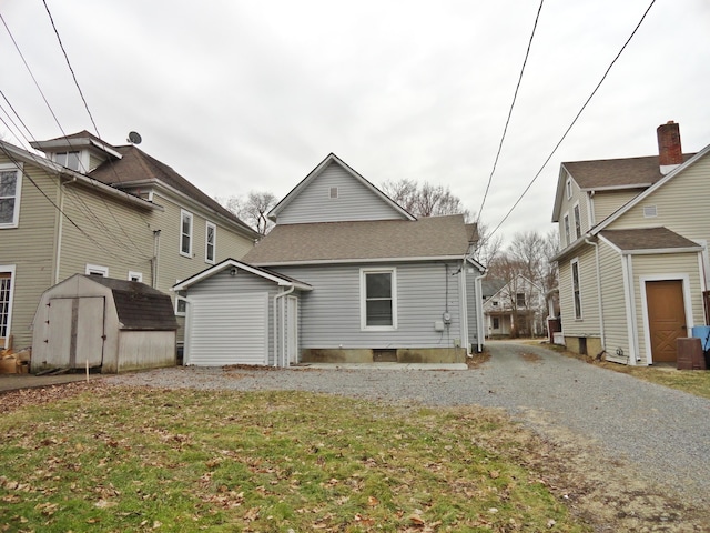 rear view of property with a lawn and a storage unit