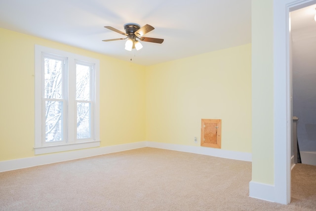 carpeted spare room featuring ceiling fan