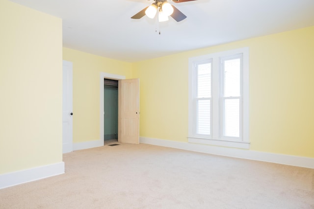 carpeted spare room featuring ceiling fan