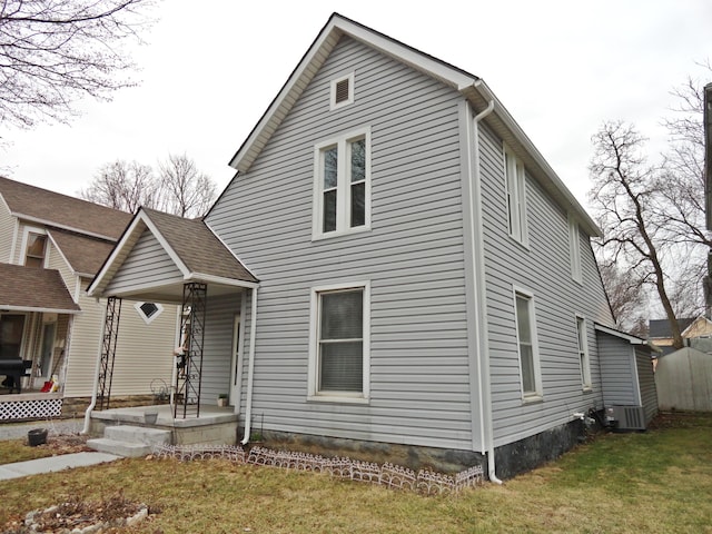 view of front facade with a front lawn, central air condition unit, and a porch