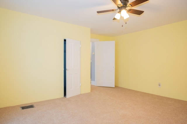 unfurnished room with light colored carpet and ceiling fan