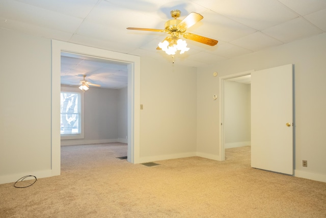 carpeted spare room featuring ceiling fan and a paneled ceiling