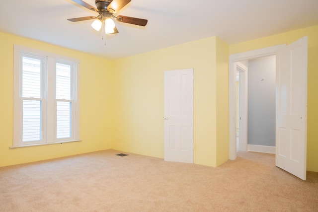 carpeted empty room featuring ceiling fan