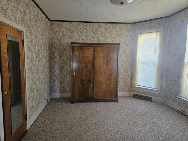 unfurnished bedroom with visible vents, multiple windows, ornamental molding, carpet floors, and wallpapered walls