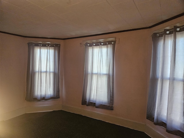 unfurnished room with baseboards and ornamental molding