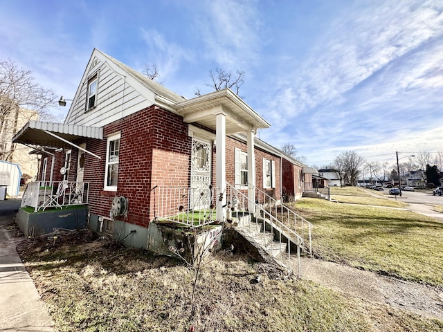 view of home's exterior with a yard and brick siding