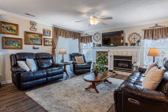 living area featuring a fireplace, crown molding, dark wood-style floors, and ceiling fan