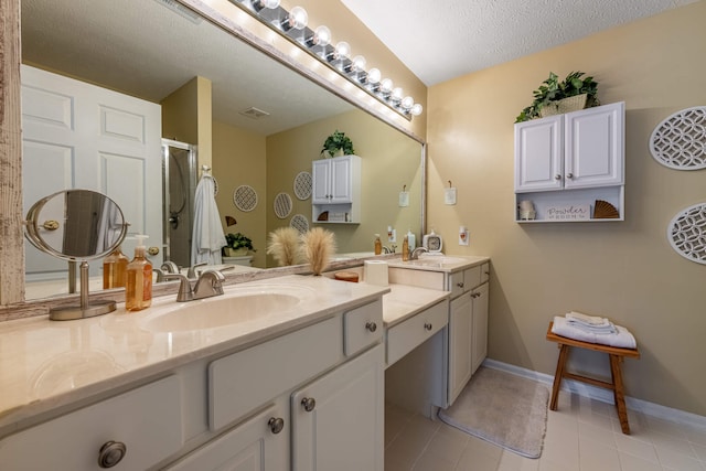 bathroom featuring tile patterned flooring, baseboards, vanity, an enclosed shower, and a textured ceiling