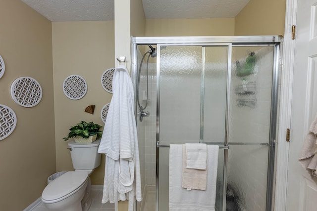 full bathroom with a textured ceiling, a shower stall, and toilet