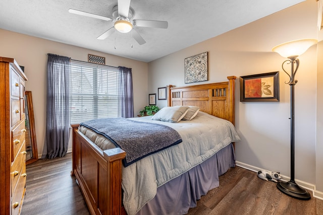 bedroom featuring dark wood-style floors, baseboards, and a textured ceiling