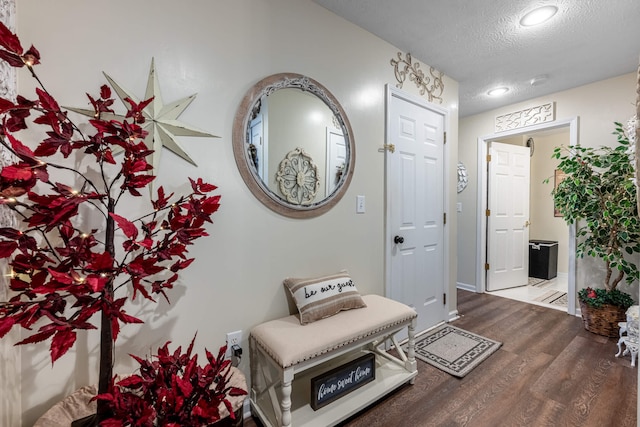 entryway with recessed lighting, a textured ceiling, baseboards, and wood finished floors