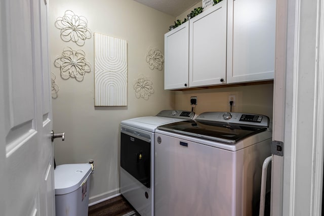 laundry room with washing machine and clothes dryer, cabinet space, and baseboards