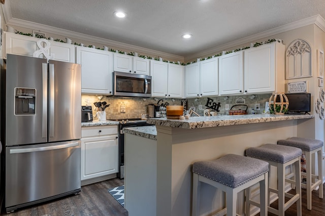 kitchen with dark wood-type flooring, a kitchen breakfast bar, white cabinetry, stainless steel appliances, and decorative backsplash