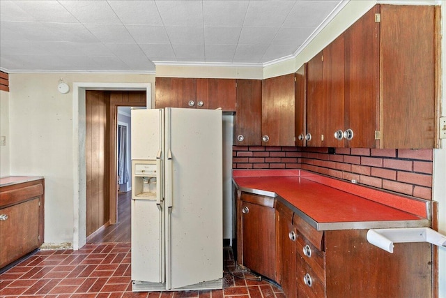 kitchen featuring crown molding and white fridge with ice dispenser