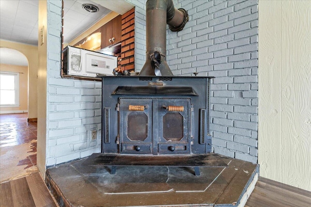 details featuring hardwood / wood-style flooring and a wood stove