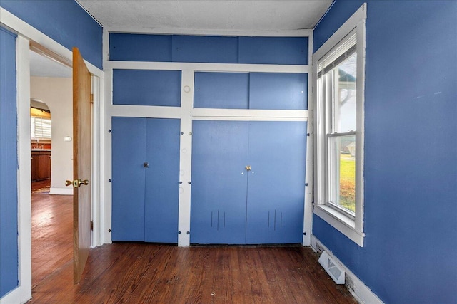 unfurnished bedroom with dark wood-type flooring