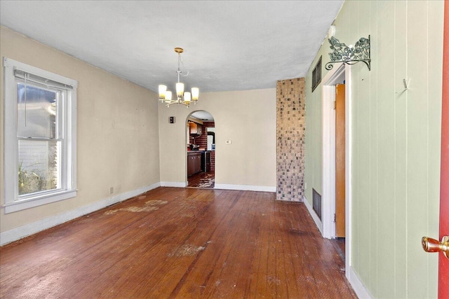 unfurnished dining area with an inviting chandelier and dark wood-type flooring