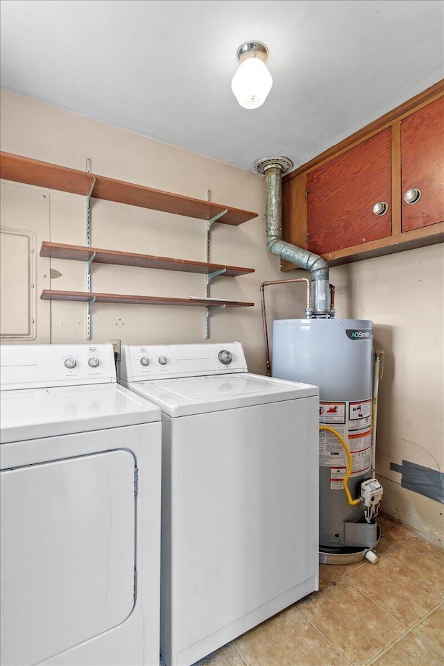 laundry room with gas water heater, cabinets, washing machine and clothes dryer, and light tile patterned flooring