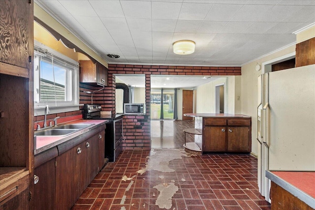 kitchen featuring sink, ornamental molding, stainless steel appliances, dark brown cabinets, and wall chimney exhaust hood