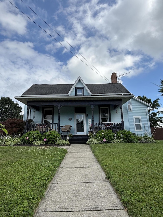 23 E Columbus Rd, South Charleston, OH 45368 - view of front of property featuring a porch, a chimney, and a front yard