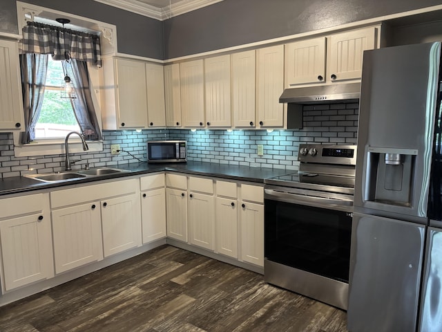 23 E Columbus Rd, South Charleston, OH 45368 - kitchen featuring appliances with stainless steel finishes, under cabinet range hood, crown molding, and dark countertops