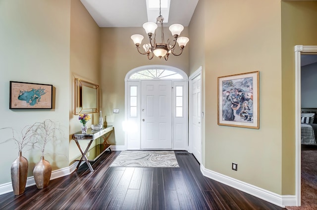 foyer with dark wood-type flooring, a high ceiling, and a notable chandelier