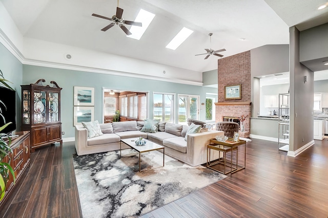 living room featuring high vaulted ceiling, a fireplace, a skylight, dark hardwood / wood-style flooring, and ceiling fan