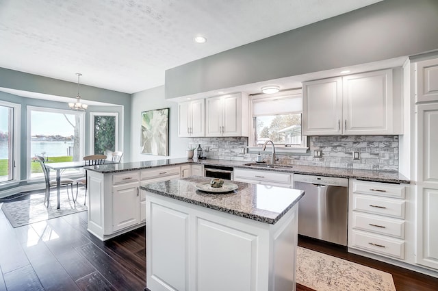 kitchen featuring pendant lighting, kitchen peninsula, a center island, and dishwasher