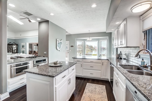 kitchen with white cabinetry, sink, a center island, and appliances with stainless steel finishes