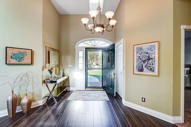 entryway with a notable chandelier, dark hardwood / wood-style floors, and a high ceiling