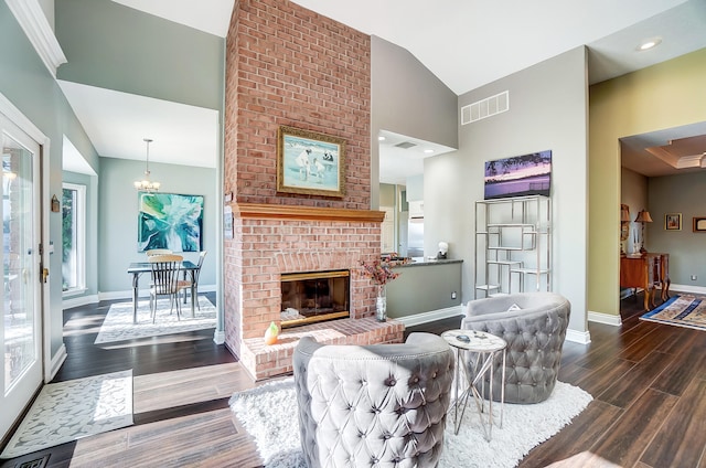 living room featuring a brick fireplace, dark hardwood / wood-style floors, high vaulted ceiling, and plenty of natural light