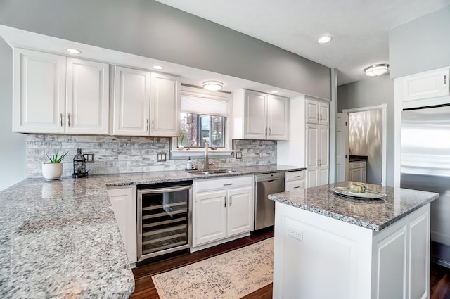 kitchen with stainless steel appliances, beverage cooler, and white cabinets