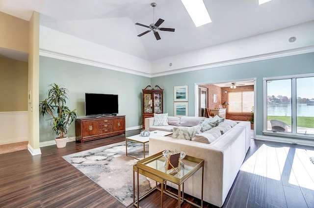 living room with dark hardwood / wood-style floors, ceiling fan, and lofted ceiling with skylight