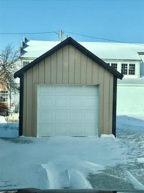 snow covered garage featuring a detached garage