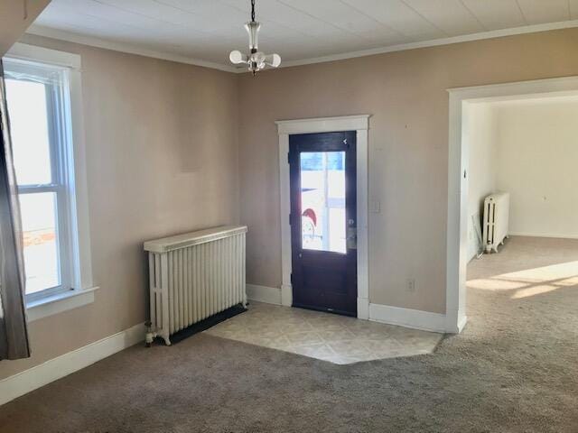 foyer with radiator heating unit, a wealth of natural light, and light colored carpet