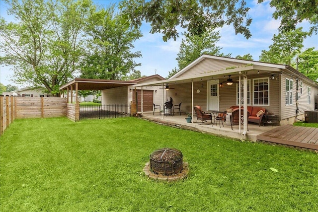 11372 Powhatan Path, Lakeview, OH 43331 - rear view of house featuring ceiling fan, a fenced backyard, a carport, a patio, and an outdoor living space with a fire pit