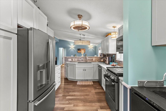 11372 Powhatan Path, Lakeview, OH 43331 - kitchen featuring stainless steel appliances, dark wood-style flooring, a peninsula, white cabinets, and a textured ceiling